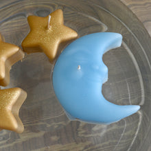 Load image into Gallery viewer, sky blue crescent moon candle floating in a bowl with three small golden star shaped candles