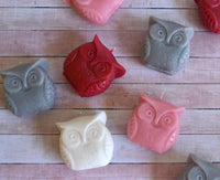 seven owl shaped candles resting on a pink wooden background. Bulk buy candles are perfect for retailers, gift industry and party supplies.