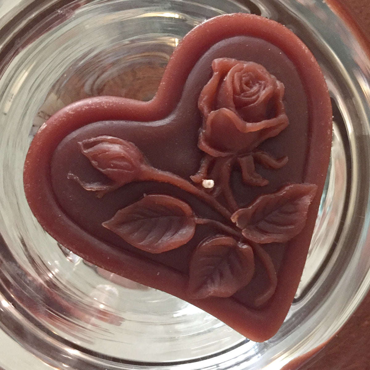 chocolate brown floating heart candle with rose motif for wedding reception centerpieces
