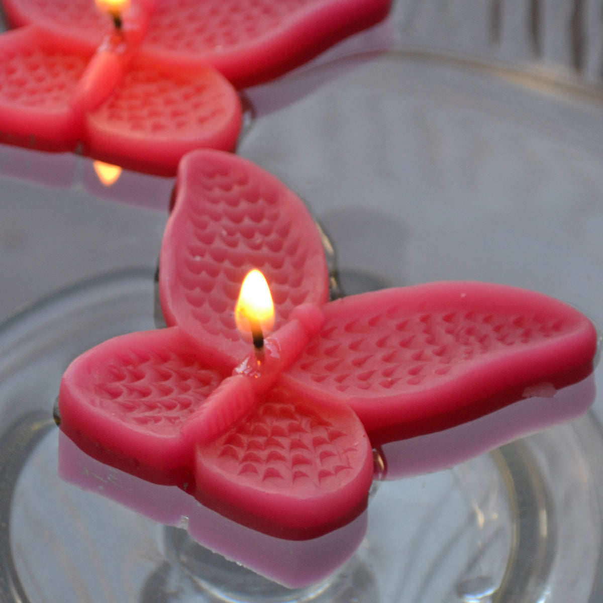 set of eight guava butterfly shaped floating wedding candles for reception centerpieces