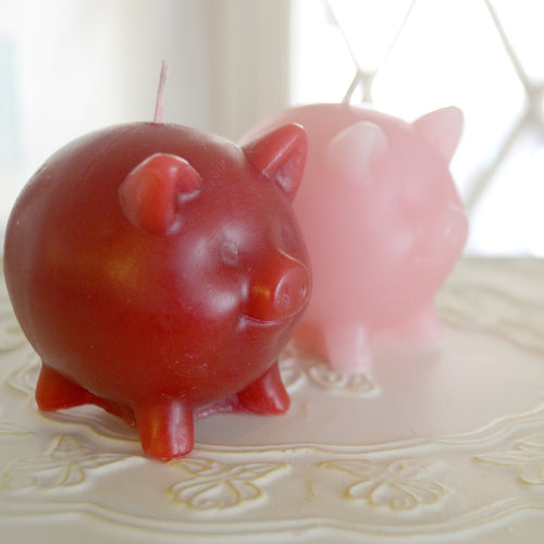 set of two pig candles red and pink scented in black raspberry vanilla